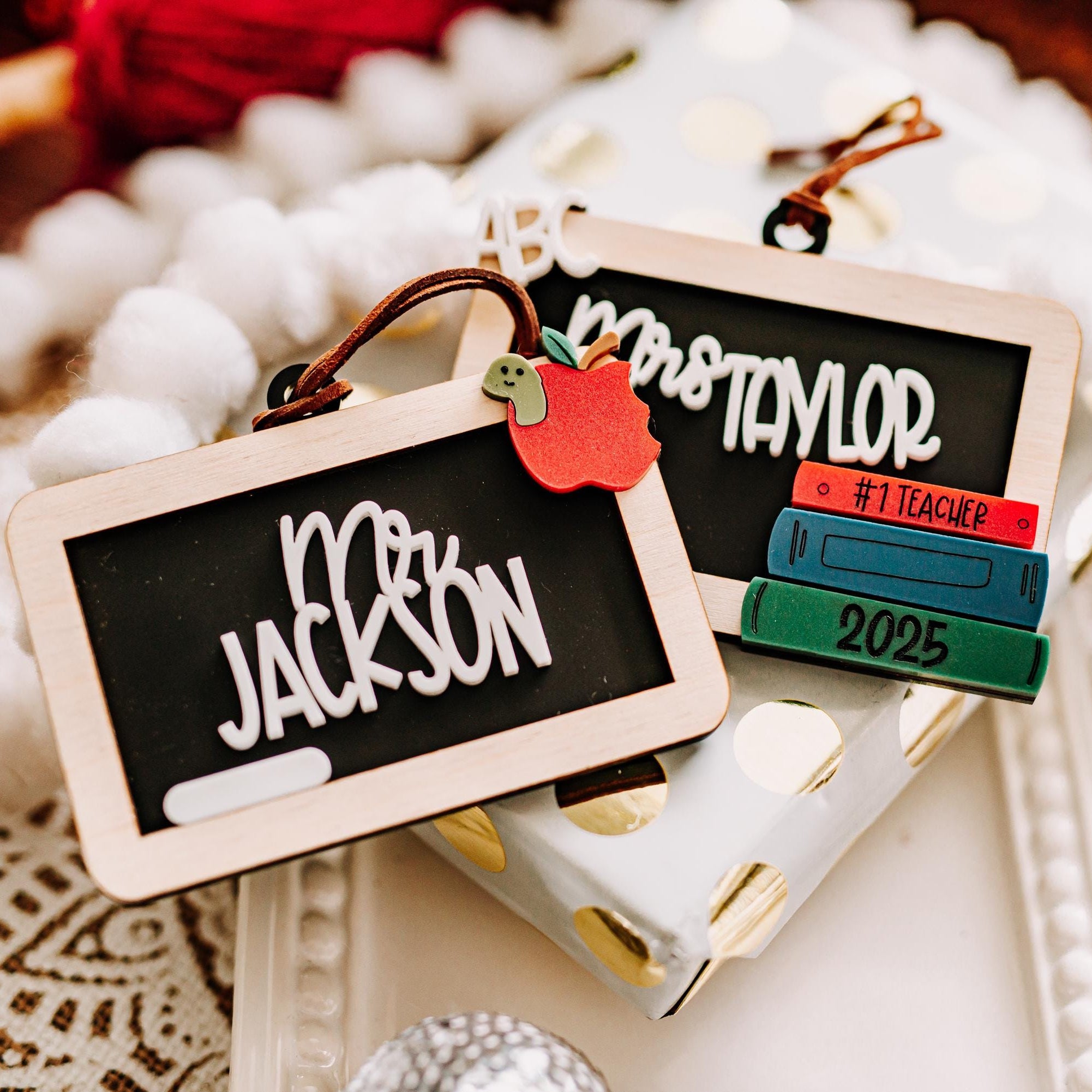 Personalized chalkboard-style ornaments hanging from a string, with one reading "Mr. Jackson" and the other reading "Mrs. Taylor"