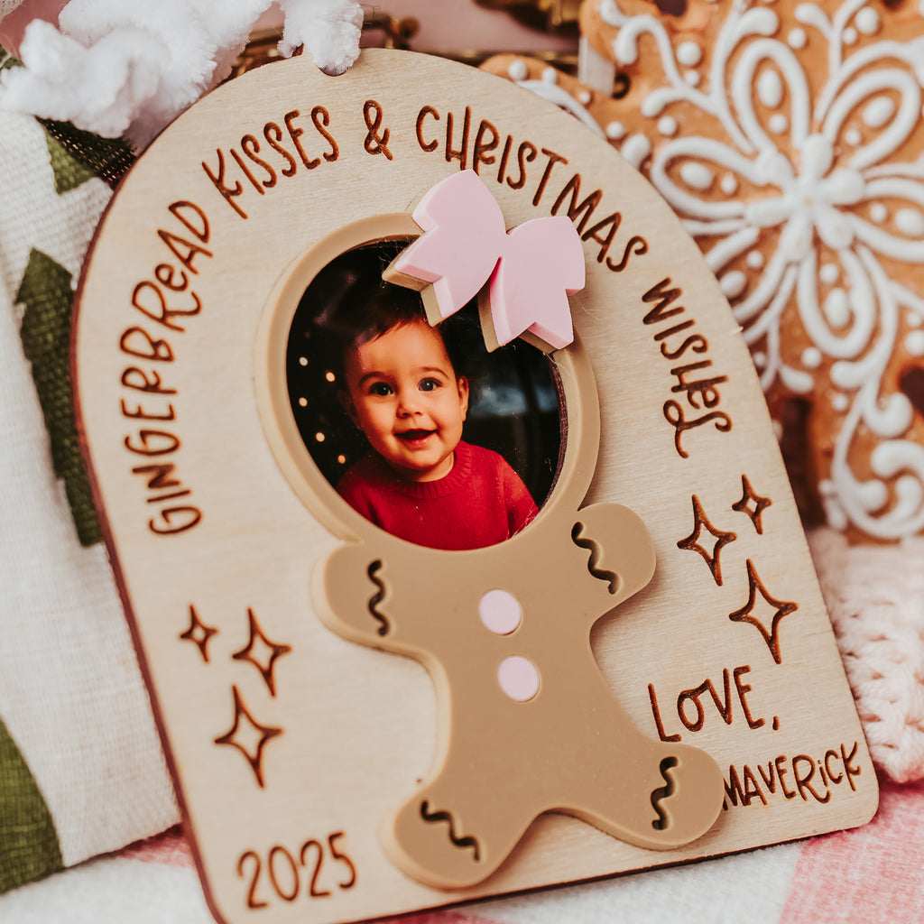 A personalized gingerbread ornament photo  featuring a photo of a smiling child, with the text 'Gingerbread Kisses & Christmas Wish' and 'Love, Maverick 2025'.